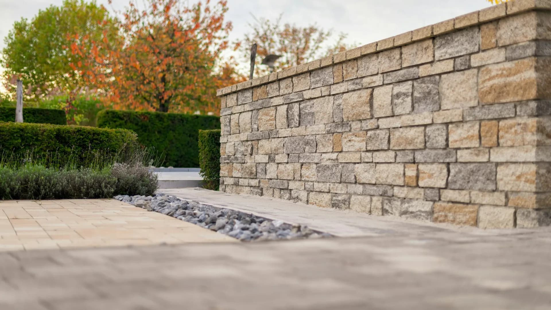Natural stone garden wall and paver walkway on a residential property