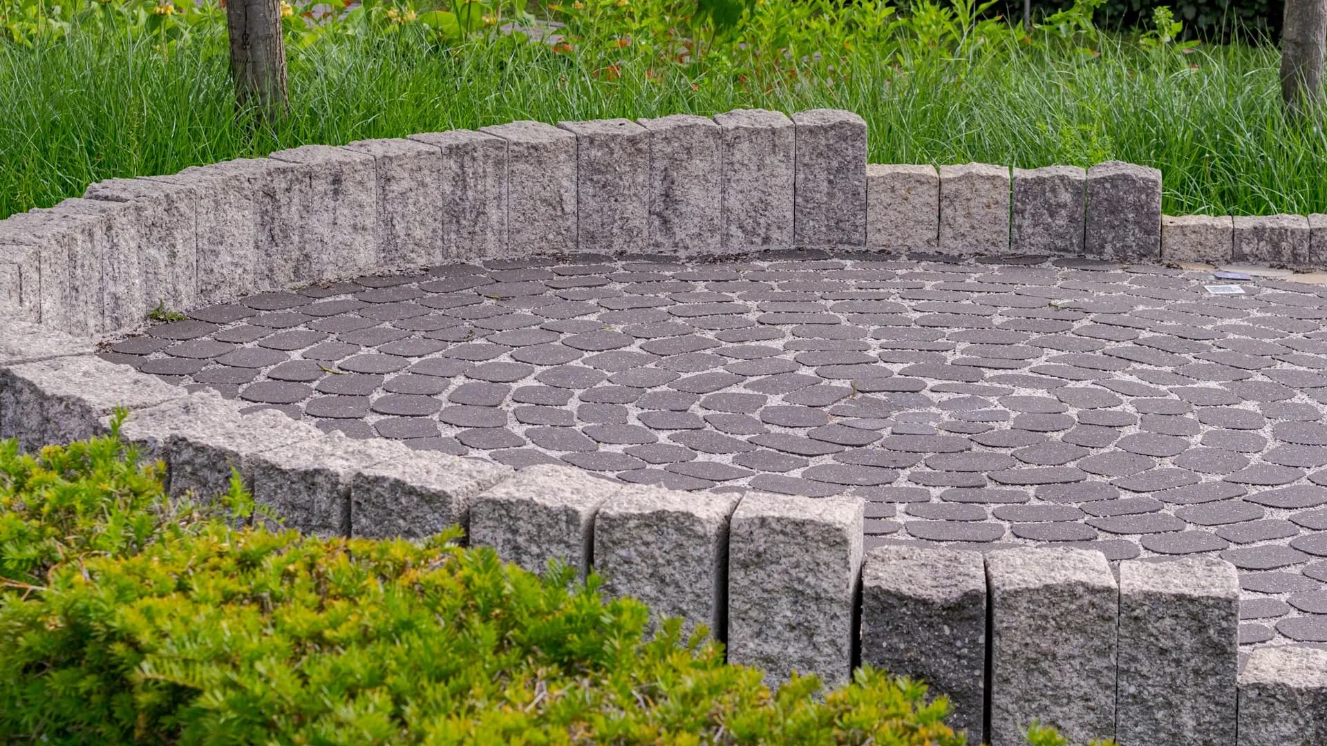 Finished circular paver patio with a natural stone border