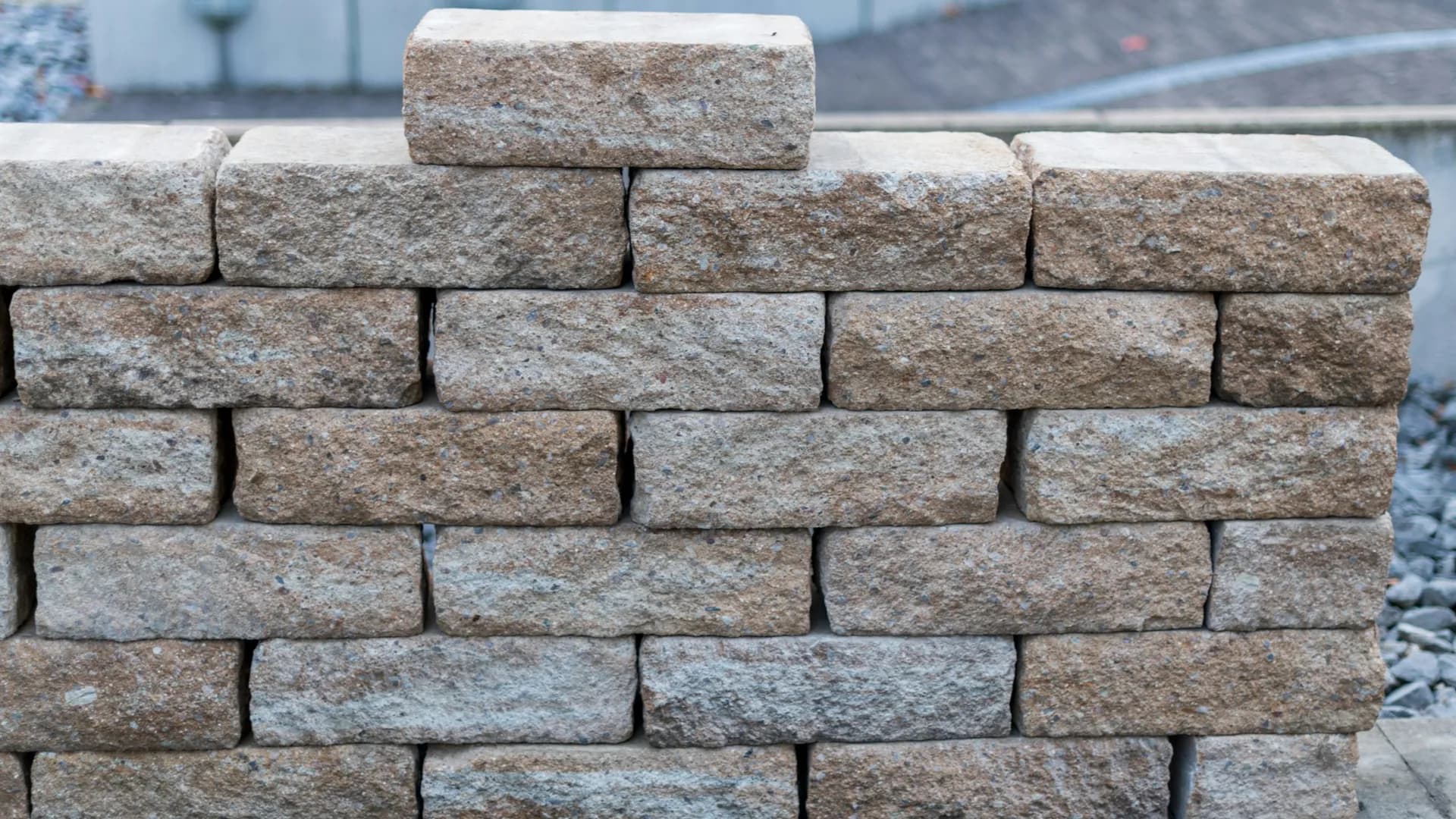 Hand-stacked segmental block retaining wall built by our masonry crew